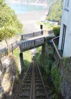View from the balcony of a car about to descend from Lynton to Lynmouth. Note the slight widening of the tracks at the half way passing point in the cutting. The River Lyn, from which the water to power the railway is drawn off at the upper level, can just be seen through the bridge railings as it reaches the sea.<br><br>[Mark Bartlett 17/05/2014]