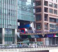 A DLR service about to leave Heron Quays station, squeezed between the various office buildings, on 26 May 2014.<br><br>[John Thorn 26/05/2014]