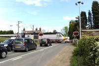 A southbound HST runs over the level crossing at Chevington, Northumberland (station closed 1958) on 17 May 2014.<br><br>[Peter Todd 17/05/2014]