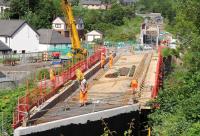 Raising the deck of the bridge over the Gala Water on 9 June 2014. Beyond is the bridge over Wheatlands Road, which received its new deck on 10/11 May. In the background is the double arch bridge carrying Kilnknowe Place - the western arch once spanning the Peebles loop, which left the main line at Kilnknowe Junction.<br><br>[John Furnevel 09/06/2014]