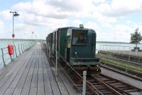 One of the UK's more unusual commuter lines, the Hythe Pier Tramway maintains a half hourly service to connect with the Southampton Ferry 363 days a year. One of the two 97 year old Brush 3rd rail electric locos is seen here approaching the station at the landward end of the pier on 25 May 2014.<br><br>[Mark Bartlett 25/05/2014]