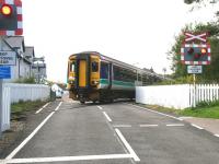 A Mallaig - Glasgow Queen Street service leaves Morar station on 27 September 2005 via the B8008 automatic warning light controlled open level crossing. <br><br>[John Furnevel 27/09/2005]