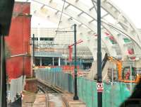 While Manchester Victoria's Metrolink area is being rebuilt there is temporary single line working through the area (and the tramstop is closed to passengers). This is the view over the driver's shoulder on a Bury bound tram showing the ongoing construction work as it passes the site of the famous <I>Hole in the wall</I>. [See image 33280] for the same location in 2011.<br><br>[Mark Bartlett 09/06/2014]