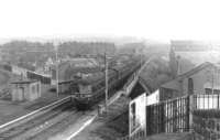 A northbound Cravens DMU crossing Battlefield Road on the approach to Mount Florida in the early 1960s. The building on the right is the former Langside tram depot, opened in 1901 and converted to a bus garage from 1957. Operations ceased here in 1984 and housing now occupies the site.<br><br>[David Stewart //]