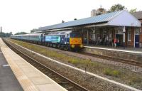 Locomotives and stock hired in from DRS by FTPE, forming a Liverpool - Scarborough service heading east at speed through platform 4 of Stalybridge station on 5 July 2014. The train consists of 47853 with a rake of DRS liveried Mark 2 coaches and 47841 on the rear.<br><br>[John McIntyre 05/07/2014]