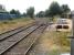 View south from Llandovery Station over the end of the station loop in August 2013. Bagged ballast and a stack of new wooden sleepers with chairs stand alongside the engineers siding accessed off the northbound platform line. [Ref query 9186]<br><br>[David Pesterfield 01/08/2013]