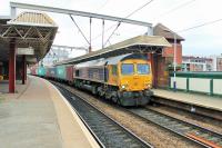 Nearing the end of a long journey from Felixstowe, GBRf 66741 rumbles through Deansgate station on 6 August heading for the Trafford Park freight terminal with a lengthy train of containers.<br><br>[Mark Bartlett 07/08/2014]