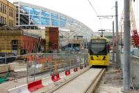 As the new roof at Manchester Victoria is installed by two huge cranes, Bury and Rochdale trams continue to pass on the temporary single line. Metrolink 3003 drops down from Shudehill to pass through the building site heading for Bury on 6th August 2014. <br><br>[Mark Bartlett 07/08/2014]