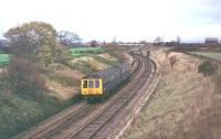 A Derby Class 108 DMU approaches Farington Curve Junction with a service from Ormskirk to Preston in 1978. At this time the former Preston to Liverpool main line was still double track as far as Midge Hall but singled not long after the picture was taken.  <br><br>[Mark Bartlett //1978]