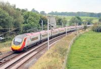 A London bound Pendolino hurries south through Grayrigg on 5 September. Immediately behind the train the points where the Up Loop rejoins the main line can be seen. Long closed Grayrigg station and the still used loops are behind the camera. Often photographed in steam days, Grayrigg station is now a mass of catenary and gantries surrounded by trees and no longer accessible. <br><br>[Mark Bartlett 05/09/2014]