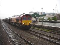 DBS 66135 runs slowly east through Cardiff Central with a freight in heavy rain on 4 June 2014.  The lengthy train consists of loaded BYA and continental covered steel wagons.<br><br>[David Pesterfield 04/06/2014]