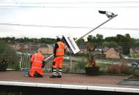 The last post. Final adjustments being made to the platform <I>furniture</I> at Baillieston on 1 October 2014. Part of the finishing touches in connection with the electrification of the Whifflet line. <br><br>[Colin McDonald 01/10/2014]