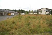 Rail approach to the station site at Selkirk in July 2014. View south west towards the site of the old terminus, much of which is now occupied by the modern headquarters of the Scottish Borders Housing Association. The distinctive Forest Mill, running along the edge of the station site still stands, although the building has since been converted to individual workshops and industrial/commercial premises. [See image 48174]<br><br>[John Furnevel 30/07/2014]