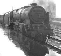 <I>'...and how was the weather in Blackpool?'</I> A returning summer Saturday holiday extra stands in the rain at Carlisle platform 1 on 17 August 1963. The train is the 10.35 ex-Blackpool Central, conveying through coaches for Perth and Edinburgh Princes Street. Royal Scot no 46128 <I>'The Lovat Scouts'</I> has just taken over the train which had arrived earlier behind Blackpool Central shed's Jubilee 45571 <I>South Africa</I>. [See image 39966]<br><br>[K A Gray 17/08/1963]