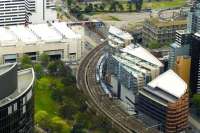 Two Metro emus passing on the 90 degree curve between Melbourne's Flinders Street Station (off to lower right) and Southern Cross (off to upper right). View from The Skydeck of the nearby Eureka Tower in October 2014.<br><br>[Colin Miller 02/10/2014]