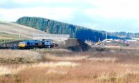 Looking north towards Falahill village on 10 November 2014. On the left GBRf 66736+66752 continue their steady progress south with the tracklaying train. In the right background is the recently opened road bridge which now carries the realigned A7 over the new railway.   <br><br>[Ewan Crawford 10/11/2014]