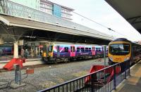 TPE 350402 pulls in to Manchester Airport Platform 2 on a service from Glasgow on 2nd December. It will quickly be serviced before heading north again to Edinburgh. Alongside in Platform 1, TPE 185125 waits to depart for Cleethorpes.<br><br>[Mark Bartlett 02/12/2014]