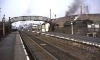 Platform view north through Kirkconnel station on 2 April 1965. On the right beyond the fence are the exchange sidings serving Fauldhead Colliery, the junction for which stands between the end of the up platform and the signal box. Fauldhead Colliery closed in 1968 [see image 33171].<br><br>[John Robin 02/04/1965]