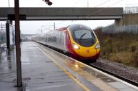 The 1300 London Euston - Manchester Piccadilly Virgin Pendolino service runs north through a wet Milton Keynes Central at speed on 3 January 2015.<br><br>[John Steven 03/01/2015]
