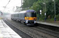 The pantograph of a Heathrow Express exerts a squeegee effect on the overhead wire as it speeds through Ealing Broadway in a rainstorm in July 2005 heading for the airport.<br><br>[John Furnevel 20/07/2005]