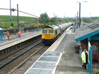 Freightliner 66617 brings a southbound cement train through Alnmouth station in May 2004. <br><br>[John Furnevel 27/05/2004]