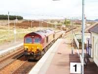 66247 heads south through Dalwhinnie with wagons, some of which contain redundant track, 31/05/05.<br><br>[John Gray //]