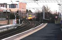 Platform view east from Partick station on a February afternoon in 2005 as a train for Milngavie approaches. Yorkhill Hospital stands in the left background.<br><br>[John Furnevel 23/02/2005]