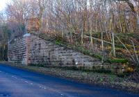 A January 2015 view showing the surviving southern abutment of the double track bridge that carried the railway over the A719 north of Maidens station and south of the goods yard. This section of the line closed completely in 1956.<br><br>[Colin Miller 03/01/2015]