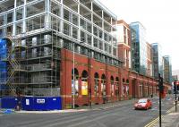 The changing face of Glasgow. Looking west along Duke Street towards Glasgow city centre on 27 January 2015. The surviving facade of the former High Street goods depot has been incorporated within the new buildings that now line the route. [See image 28141]<br><br>[Colin McDonald 27/01/2015]