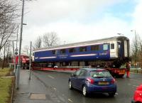 A Caledonian Sleeper Lounge Car emerging from the car park area at St. Rollox by road on 16 April 2013. The shiny new red springs suggest it has been receiving attention at RailCare.<br><br>[Colin McDonald 16/04/2013]