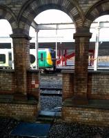 The built environment: a 350 heading for Liverpool Lime Street calls at Crewe's platform 12 in January 2015. The chequered sign to the left of the gap in the wall reads 'Limited Clearance'.<br><br>[Ken Strachan 28/01/2015]