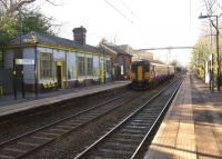 The platforms of Eccleston Park station on the Wigan to Huyton line on 3 February 2015, looking roughly south west as a Liverpool bound service passes through.<br><br>[John McIntyre 03/02/2015]
