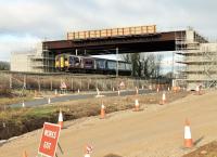 The deck of the new Heysham link road bridge was put in place over the WCML near Morecambe South Junction in January 2015. 150224 passes under the new structure on 9th February on a Morecambe to Leeds working that has just left the Morecambe branch. [See image 48728]  taken a few months earlier. <br><br>[Mark Bartlett 09/02/2015]