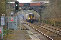 Looking north from the platform at Farnworth station on 5 February 2015 as a Northern service to Manchester Victoria approaches. Through the various bridges along this straight the up platform at Moses Gate station can just be made out.<br><br>[John McIntyre 05/02/2015]