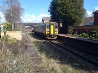 The 1248 service to Ormskirk departs from Croston station on 10 March 2015. Daffodils are out on the right while the tidy up of the south end of the old Preston platform continues, with several tree stumps awaiting removal. [See image 36136]<br><br>[John McIntyre 10/03/2015]