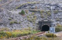 The southern portal of the 2 mile 333 yards Ffestiniog Tunnel in March 2015. The contrast between the rural area around the northern portal at Roman Bridge and the <I>moonscape</I> found when emerging here is always amazing and the train continues through the slate heaps for almost a mile to the present day station. One of Blaenau's numerous old inclined planes can be seen top left.<br><br>[Mark Bartlett 15/03/2015]