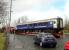 A Caledonian Sleeper Lounge Car emerging from the car park area at St. Rollox by road on 16 April 2013. The shiny new red springs suggest it has been receiving attention at RailCare.<br><br>[Colin McDonald 16/04/2013]