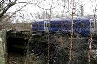 Heading east away from High Street station on 3 February 2015, unit 334035 crosses the cutting leading to the former Bridgeton Central station. After the old station closed in 1979, the line was maintained for access to the Bridgeton EMU maintenance depot until 1987, following which the tracks were lifted.<br><br>[Colin McDonald 03/02/2015]