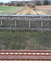 Looking west along the route of the former Roslin branch at the point where the trackbed has now been breached by the Borders Railway between Shawfair station and the Edinburgh City Bypass. The south end of Millerhill Yard is behind the camera [see image 50522]. The modern building in the left background is a private hospital, part of the new Shawfair development. <br><br>[John Furnevel 01/03/2015]