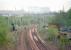 View east to Gartsherrie South Junction from Gartsherrie North Junction in 1989.<br><br>The Garnkirk and Glasgow Railway's 1831 alignment was a little to the left and continued straight on to join the 1826 Monkland and Kirkintilloch at its Gartsherrie station, opened with the junction. The line curving to the right is the 1843/5 extension to the WM&C at Whifflet built by the G&G. It renamed itself the Glasgow, Garnkirk and Coatbridge in 1844. From left to right is the 1848 alignment built by the Caledonian Railway from Gartsherrie South Junction to Gartsherrie East Junction to gain access via a short section of the M&K to its line from Garnqueen South Junction to Greenhill. This spur crossed the original G&G line on the level. The containers in the background are on the site of Gartsherrie Ironworks with Coatbridge FLT off picture to the right. There were two Gartsherrie stations, one on the GG&C (1843 to 1940) and another earlier one (1831 to 1849) on the M&K near Gunnie Yard. The G&G had an inn (opened 1833) at Gartsherrie and may have had their own station close to the M&K junction.<br><br>Gartsherrie North Junction was between the original G&G line and the later extension to Whifflet.<br><br>[Ewan Crawford //1989]