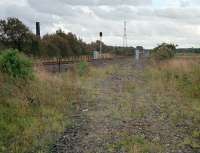 Garnqueen South Junction looking south towards Coatbridge. This view was taken over a fence looking to the former junction site in 1987. The signalbox from here can now be found at re-erected at Bo'ness [see image 20613]. The chimney belonged to the closed Gartliston Fireclay works.<br><br>[Ewan Crawford //1987]