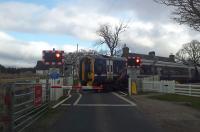 158703 heads southbound over the level crossing at Forsinard in April 2015.<br><br>[Rod Crawford 23/04/2015]