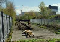 View through the fence at the end of the line at Powderhall refuse depot in 1999. Note the anchored yellow box for the looped steel cable, used to position the container flats during loading and unloading [see image 12012].<br><br>[Ewan Crawford //1999]