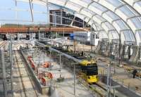 The new three line Metrolink platforms arrangement at Victoria is now taking shape, and trams are calling again although work is not yet finished. With the roof cladding now in place, a double tram for Bury pulls into the centre road on 20th April 2015. [See image 49339] for the same location six months earlier. <br><br>[Mark Bartlett 20/04/2015]