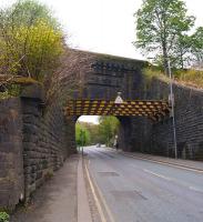 Looking up Stoneclough Road in Kearsley under the railway bridge on 10 May 2015. The station entrance is beyond the bridge on the right. There has been some significant bracing applied to the retaining walls on this side of the bridge.<br><br>[John McIntyre 10/05/2015]
