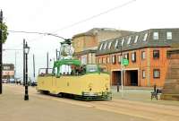The graceful lines of Blackpool <I>Boat Car</I> No. 230 are seen to good effect in Pharos Street at Fleetwood as it pauses at the heritage tram stop before returning to the Pleasure Beach. The hardy souls on board this service were well wrapped up. The modern building at the end of the street stands on the site of Fleetwood Railway Station, closed in 1966.  <br><br>[Mark Bartlett 24/05/2015]