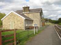Looking east along the platform at Redmire Station on the Wensleydale Railway, with the well maintained station building now used by the Scouting Organisation. Sidings for the occasional loading or off-loading of military vehicles to or from Catterick Garrison are located behind the camera.<br><br>[David Pesterfield 25/05/2015]