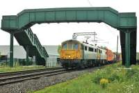 Freightliner 86604 and 86613 take the Coatbridge to Crewe containers under the footbridge at the site of Brock station on 2nd June 2015. Practically guaranteed to use a pair of 86s, this train is popular with photographers on summer evenings [See image 51533]. <br><br>[Mark Bartlett 02/06/2015]