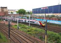 The 1530 Pendolino from London Euston approaching Eglinton Street Junction on 26th June 2015 and passing a <I>Welcome to Glasgow</I> greeting.<br><br>[Colin McDonald 26/06/2015]