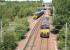 An empty ballast train runs south towards Millerhill Yard on 10 June 2015 behind DBS 66170. In the background ScotRail DMU 158736 has just left Newcraighall station on the other side of the A1 road bridge and is turning south west towards Shawfair with the 1157 driver training special to Tweedbank.<br><br>[John Furnevel 10/06/2015]